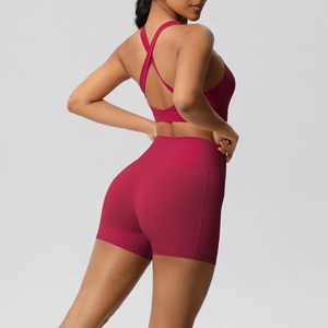 Detail view of burgundy yoga set featuring high-waisted shorts with side pocket and sports bra
