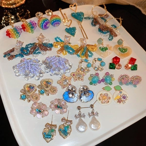 Collection de boucles d'oreilles cœurs et fleurs en cristal sur plateau en céramique