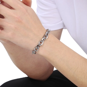 Close-up of polished stainless steel cuban chain bracelet worn on a wrist