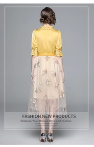 Detail of elegant yellow silk shirt and mesh skirt with colorful butterfly appliques