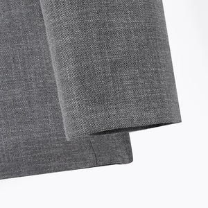 Macro shot showing gray textured fabric detail and fine stitching of the shirt and skirt set