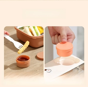 Detail view of leak-proof sauce container and secure white lid for bento lunch boxes
