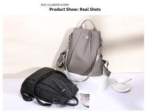 Detail view of water-resistant oxford fabric backpacks in black and taupe with metal logo