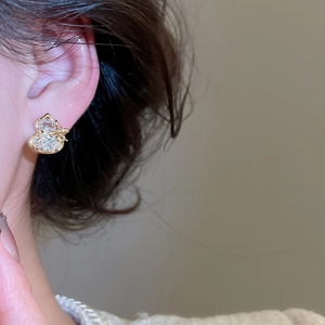 Close-up of gold-plated gourd earring with zircon inlay and butterfly bow detail