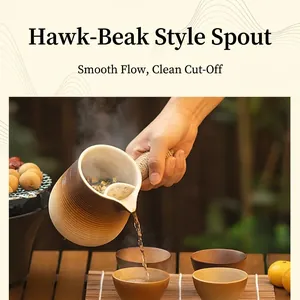 Ceramic side-handle teapot with horizontal ribs pouring tea on a wooden table