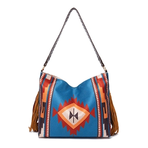 Detail of bohemian shoulder bag featuring ethnic geometric patterns and brown suede tassels