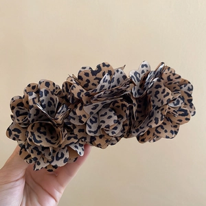 Detail shot of leopard print fabric flower hair clip with a vintage ethnic aesthetic
