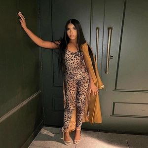 Close-up of leopard print slim jumpsuit paired with a brown wool coat and white heels