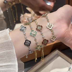 Gros plan de bracelets trèfle réglables en émail noir, vert, rouge et blanc élégants
