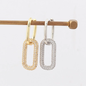 Detail of gold and silver geometric link earrings with sparkling pavé cubic zirconia