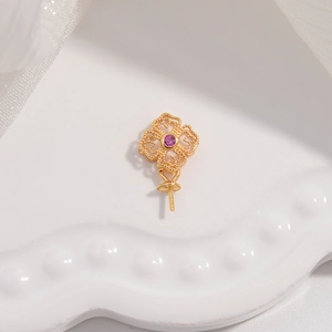 Detail of gold-plated clover pendant finding with a central purple zircon stone inlay