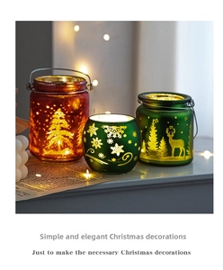 Close-up of frosted Christmas glass candle holders with reindeer and snowflake patterns