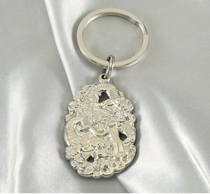 Détails du relief de dragon traditionnel sur un porte-clés en acier inoxydable poli