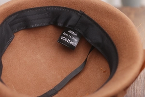 Detail view of the 100% wool label and interior sweatband of the brown wool fedora hat