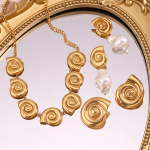 Detailed view of 18K gold plated spiral shell necklace and baroque pearl earrings set