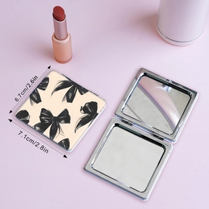 Portable folding makeup mirror with black bow pattern and silver metal frame, 7cm size