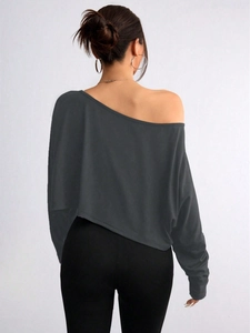 Detail of dark grey off-shoulder long sleeve top with an asymmetric hem and soft texture