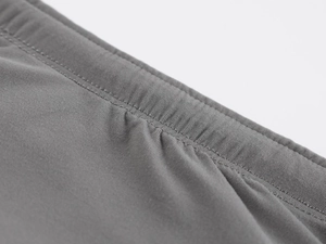 Detailed close-up of double-needle stitching on dark gray high-elastic seamless fabric