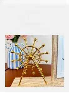 Detail of golden metal ferris wheel frame decoration with a light wooden base