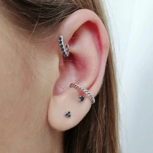 Detailed view of sterling silver earring set with black stones and twisted rope hoop on ear