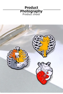 Detail of enamel cat pins featuring creative skeleton and heart anatomical designs