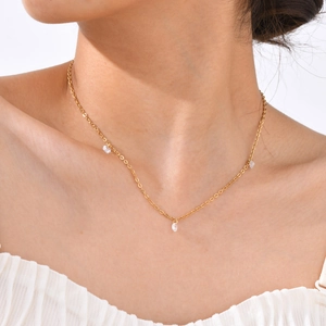 Close-up of 18K gold plated necklace featuring shimmering clear zircon pendants on a model