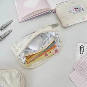 Detailed internal view of quilted cream wallet with card slots and star embroidery