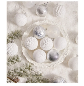 Detailed view of textured silver and white Christmas tree ornaments in a snowy setting