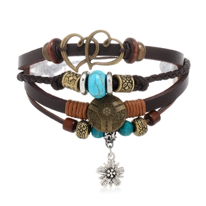 Detail eines Vintage-Lederarmbands im Boho-Stil mit Türkisperlen und Herzanhänger