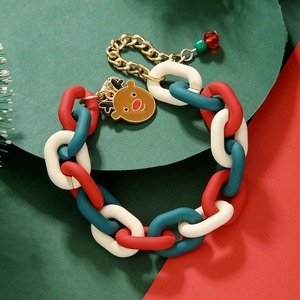 Détail d'un bracelet de Noël à gros maillons rouge et vert avec un pendentif renne doré