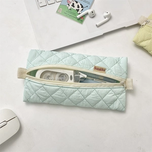 Close-up of light blue quilted pencil case with soft texture and sturdy zipper detail