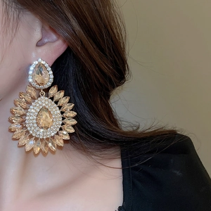 Macro shot of model wearing vintage champagne crystal teardrop flower earrings with rhinestones