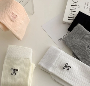 Détail de cinq paires de chaussettes en maille style ballerine avec broderie nœud