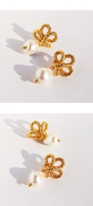 Close-up of woven knot metal bow and drop baroque pearl detail on elegant gold earrings