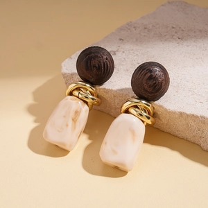 Detail shot of vintage resin earrings with gold rings and beige marbled stone pendants