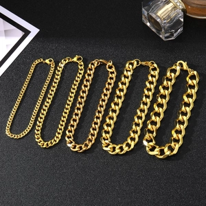 Five gold stainless steel Cuban link chains in varying thicknesses on a textured background