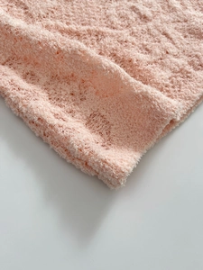 Gros plan sur la texture délicate du tricot floral rose et les détails du tissu doux