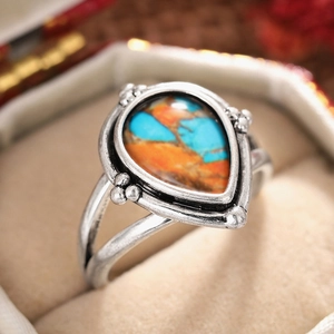 Détail macro d'une bague vintage argentée avec pierre en goutte dans son écrin