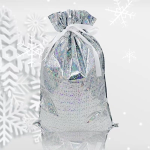 Close-up of silver laser gift bag with white drawstring and festive snowflake background