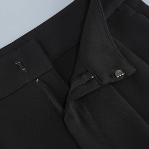 Macro shot of black trousers waist closure with hidden metal hook and zipper detail