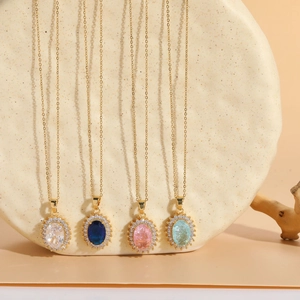 Detail view of four 14K gold-plated zircon pendant necklaces in various gem colors