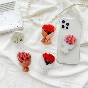 Acrylic flower bouquet phone grip holders with rose designs on white fabric background