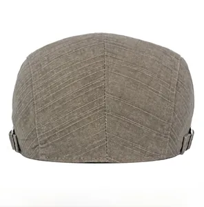 Detail view of cotton newsboy cap with adjustable metal buckles and twill texture