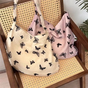 Detail of soft cotton lace butterfly tote bags on a vintage rattan wooden chair