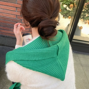 Detail view of green knitted hooded shawl showing the thick texture and hood design