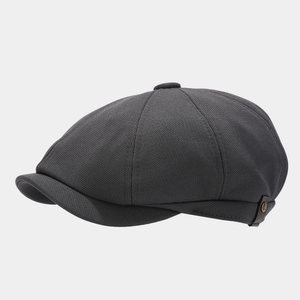 Detail view of charcoal newsboy cap with knitted texture and leather side label