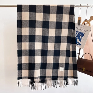 Close-up of black and beige plaid cashmere-feel scarf with elegant fringe detail