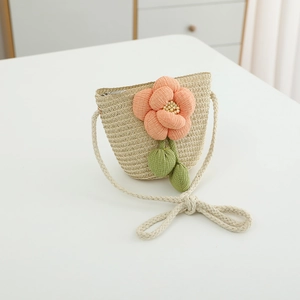 Detail der handgewebten Strohtasche mit Stoffblume und Perlen für kleine Mädchen