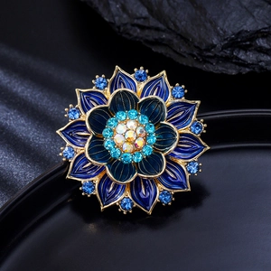 Makro-Detail der blauen Lotos-Brosche mit goldenen Emaille-Blüten und Kristallen