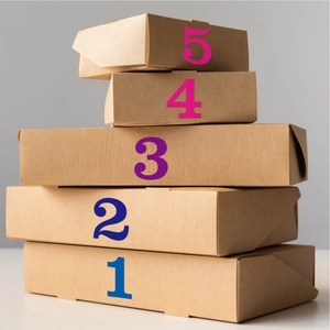 Vue détaillée de cinq boîtes cadeaux en papier kraft de différentes tailles empilées